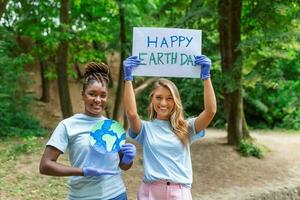 Happy Earth day. People cleaning up litter on grass. Group of international young people building team outdoor in park. Volunteer together pick up trash in the park photo
