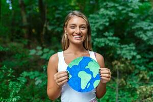 un joven mujer participación un planeta tierra y protestando en contra ambiental contaminación. foto