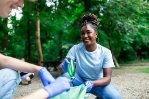 A multiethnic group of people, cleaning together in a public park, are protecting the environment. The concept of recycling and cleaning photo