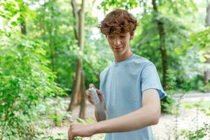 Man applying insect repellent against mosquito and tick on His arms during hike in nature. Skin protection against insect bite photo