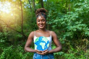 A young African-American with braided hair holding a planet earth and protesting against environmental pollution. photo