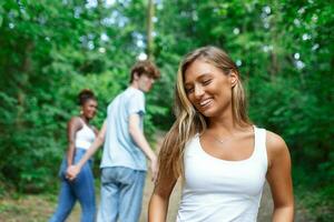 Disloyal man looking at another woman while walking with his girlfriend in park photo