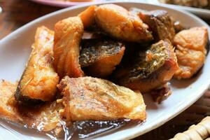 Deep fried Snapper with fish sauce on white dish photo