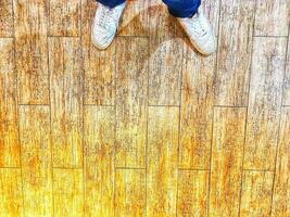 A pair of white shoes on a floor with a wooden texture. photo