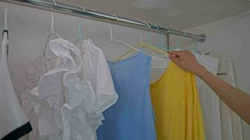 lady choosing blue and yellow shirts video