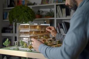 a person works with the model house in the office in the style of architectural with photo