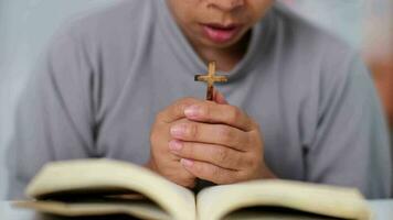 de cerca de un mujer leyendo un abierto Biblia, Orando y participación manos en su Biblia. espiritual o Biblia estudiar concepto. video
