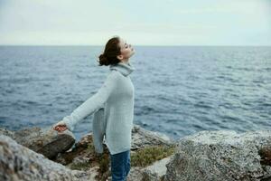 pretty woman beach tourism cloudy weather stone coast female relaxing back view photo