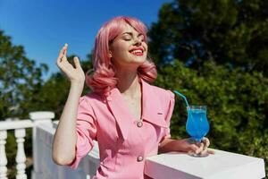 cheerful woman enjoying a colorful cocktail hotel terrace Relaxation concept photo