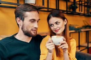 un mujer en amor con un taza de café y un contento hombre a un mesa en un café interior amigos comunicación foto