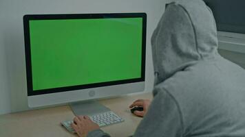 guy wearing gray hood working on pc video