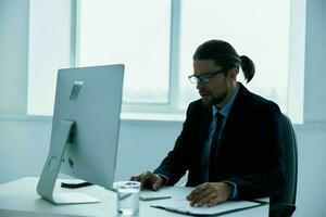 man in a suit work in front of a computer documents executive photo