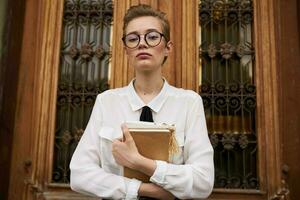 pretty woman with glasses walking around the city with a book communication photo