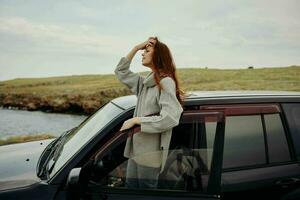 woman with red hair in a sweater near the car nature Lifestyle photo