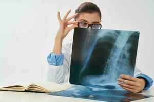 mujer sentado a mesa radiografía y medicina hospital investigación foto
