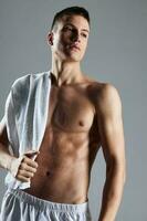 cute guy with pumped up body posing white towel studio photo