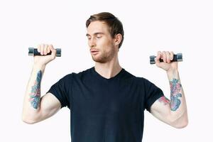 athlete with dumbbells in his hands and in a black t-shirt exercise fitness bodybuilder photo