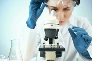 mujer en laboratorio mirando mediante microscopio de cerca biotecnología Ciencias foto