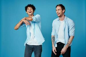 curly guy in shirt and blond man on blue background chatting friends cropped view photo