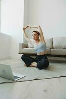 Woman exercising at home by video workout online, meditation and stretching, mental health photo