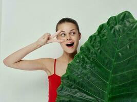 alegre mujer gesticulando con mano palma hoja traje de baño emociones foto