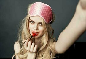 sexy blonde woman with red lipstick emotions and pink mask on her face photo