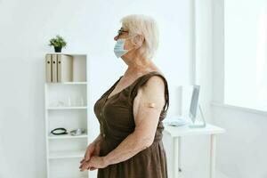 elderly woman plaster on her arm hospital covid-19 vaccination photo