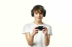 chico en blanco camiseta con auriculares jugando vídeo juegos foto