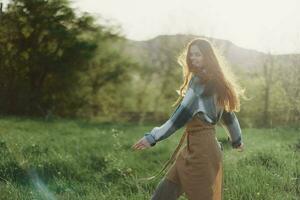 A woman running through a field on a summer day with long flowing hair in the rays of the setting sun. The concept of freedom and harmony with nature photo