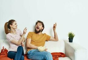 man and woman on sofa orange plaid bright room flower in a pot photo