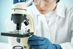 woman scientist looking through a microscope laboratory research diagnostics photo