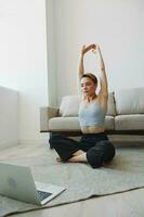 Woman exercising at home by video workout online, meditation and stretching, mental health photo