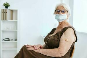 elderly woman in medical mask sitting in hospital vaccine passport photo