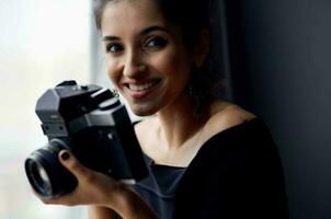 bonito mujer en un negro vestir cerca el ventana posando Moda modelo foto