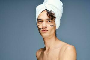 cute guy with bare shoulders towel on head cream on face photo