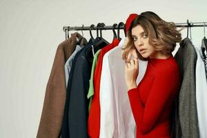 cheerful woman next to clothes fashion fun retail isolated background photo