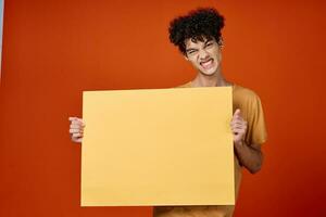 Cheerful guy with curly hair poster studio cropped view photo
