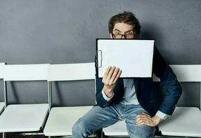 A man with a box sits on a chair with things documents dismissal photo