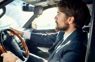 emocional hombre en un traje en un coche un viaje a trabajo Rico foto