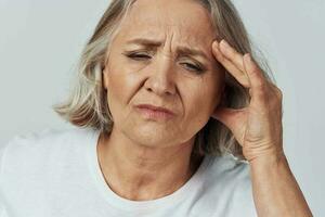 elderly woman holding her head migraine pain treatment photo