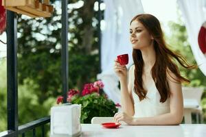 Portrait of young beautiful woman sitting in outdoor cafe street drink coffee unaltered photo