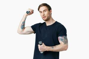 sports man in a black t-shirt with dumbbells in his hands fitness exercises photo