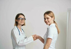 A woman in a T-shirt came to see a doctor in a medical gown photo