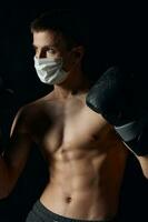 boxer wearing medical mask nude torso black background photo