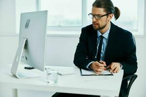 hombre en un traje un oficial es trabajando a el computadora tecnologías foto