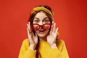 pretty woman in yellow sweater red glasses studio fashion posing photo