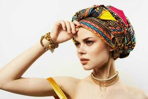 cheerful pretty woman in multicolored turban african style and fashion posing photo