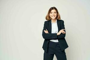 cheerful business woman in a suit gesturing with her hands work manager light background photo