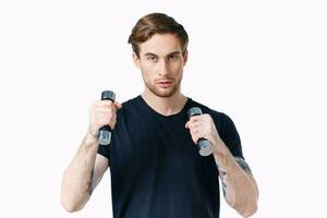 guy in a black T-shirt with dumbbells in his hand on a white background Copy Space photo