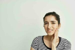 woman holding on to face toothache health care light background photo